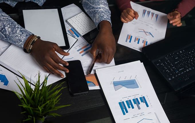 Overhead view of a team reviewing printed financial charts